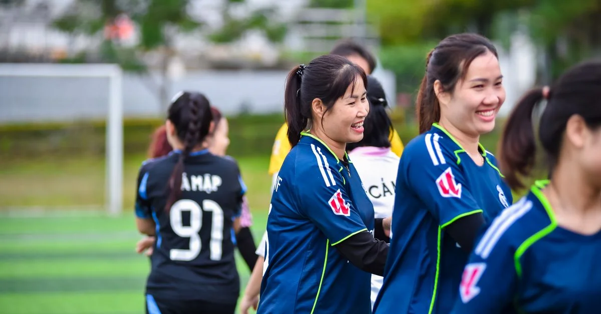 Scène vibrante d'une équipe féminine de football célébrant sa victoire sur le terrain à Hanoï, au Viêt Nam.