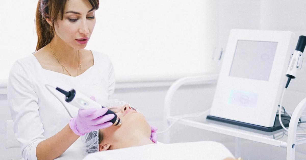 Une esthéticienne fournissant un traitement facial au laser à un patient dans un cadre de spa.