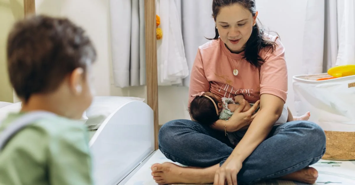 Mère passant du temps de qualité à lire à ses enfants dans un cadre intérieur confortable.