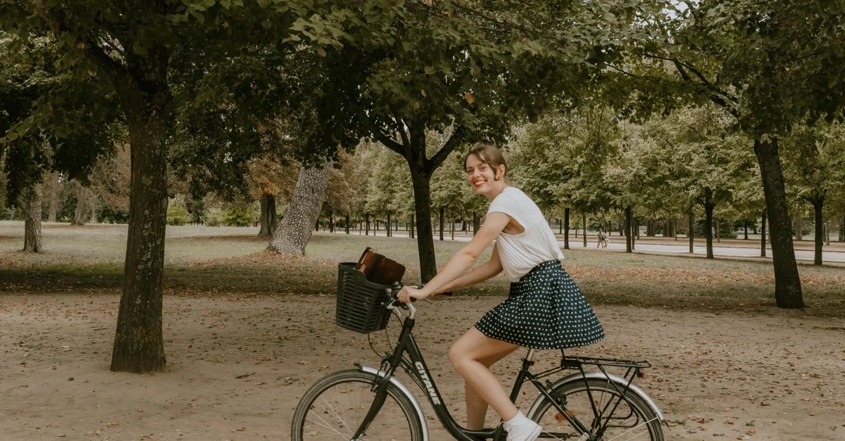 Jeune femme faisant du vélo dans un magnifique parc parisien pendant la journée.