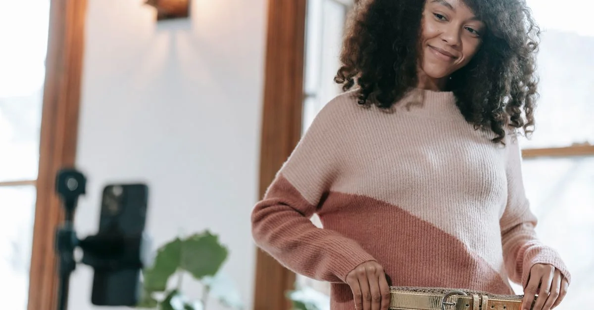 Femme souriante en train de poser avec un pull en maille confortable à l'intérieur, capturant un moment de mode décontracté.
