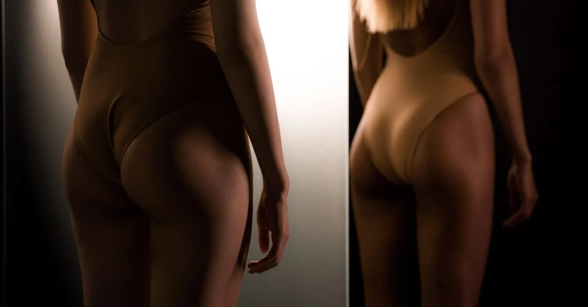 Vue élégante de dos d'une femme en maillot de bain avec un éclairage dramatique et des reflets.