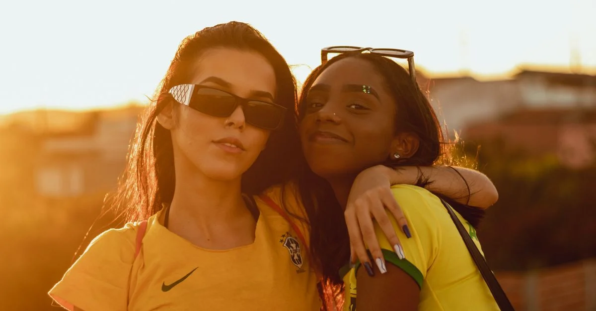Deux femmes à la mode avec des lunettes de soleil profitant d'un vibrant coucher de soleil en plein air.