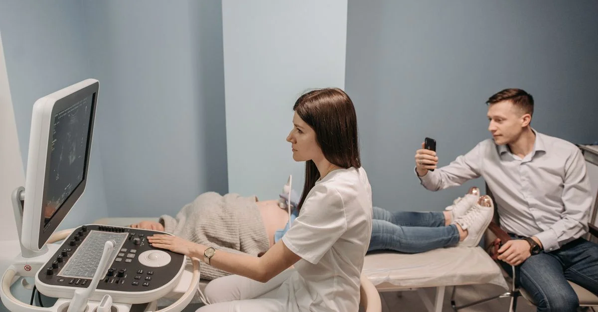 Un professionnel de la santé effectue une échographie pour un couple en attente dans une clinique.